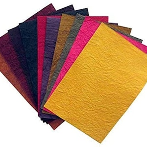 May include: A selection of textured paper sheets in a range of colours, such as gold, pink, purple, and brown. The paper has a crinkled texture, possibly indicating a handmade or artisanal finish. Suitable for crafts, scrapbooking, or creative uses.