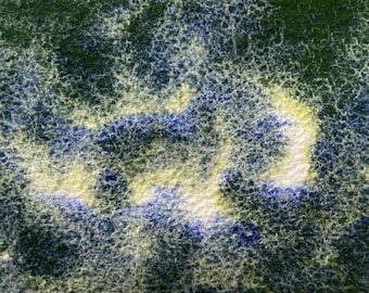 May include: A close-up of a textured surface with a blue and yellow abstract pattern. The surface appears to be made of paper or fabric.