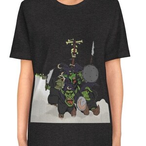 May include: A dark heather grey t-shirt featuring a graphic print of a group of green goblins wearing black hats and holding weapons. The goblins are flying through the air.