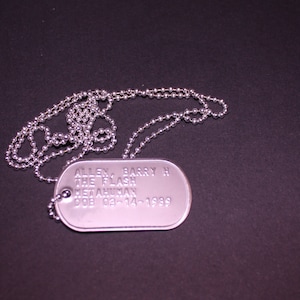 Peut inclure: Collier avec une médaille d'identité en argent et une chaîne. La médaille porte l'inscription "ALLEN BARRY H THE FLASH METAHUMAN DOB 03-14-1989".