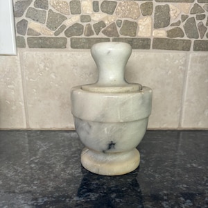 White and Gray mortal and postle, 4” tall x 4”, pestal is 3 1/2”