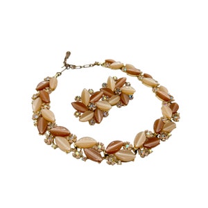 May include: A vintage gold tone necklace and earrings set with brown and cream colored oval shaped stones and clear rhinestones.