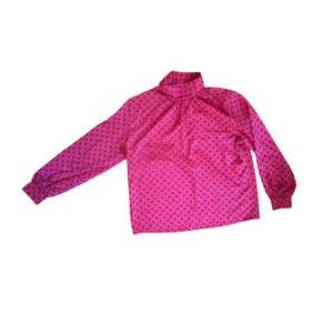 May include: A bright pink blouse with a high neckline and long sleeves. The blouse features a repeating pattern of small, dark purple squares. The sleeves have buttoned cuffs. The blouse is made of a shiny, silky material.