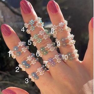 Puede incluir: Diez anillos de cuentas con dise&ntilde;os de flores en varios colores, incluidos azul, verde, morado y blanco. Los anillos est&aacute;n numerados del 1 al 10.