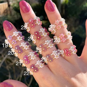 Puede incluir: Un conjunto de diez anillos de cuentas con flores de diferentes colores. Los anillos est&aacute;n numerados del 19 al 29.