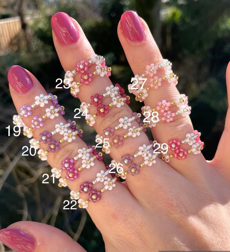 Puede incluir: Un conjunto de diez anillos de cuentas con flores de diferentes colores. Los anillos est&aacute;n numerados del 19 al 29.
