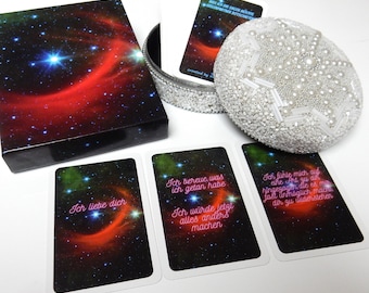 May include: A set of affirmation cards with a galaxy background. The cards feature pink neon text with phrases like "I love you", "I regret what I did", and "I would do anything differently".