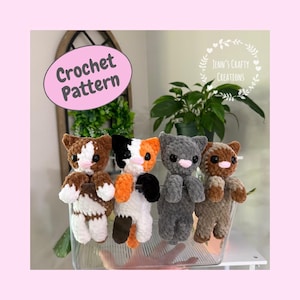 May include: Four plush crochet cat toys in a clear container. The cats are brown and white, calico, solid gray, and light brown. Each has black eyes and a pink nose. A pink oval graphic reads Crochet Pattern and a logo reads Jenn's Crafty Creations.