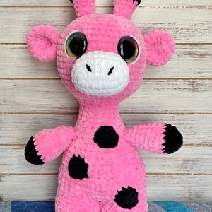 K&ouml;nnte beinhalten: Rosa geh&auml;keltes Giraffen-Pl&uuml;schtier mit schwarzen Flecken und gro&szlig;en Glitz Augen.