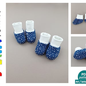 May include: A pair of blue baby booties with white polka dots and white cuffs. The booties are laid out on a light brown surface. The image includes the text "JULA.W/ patterns" in rainbow colors.