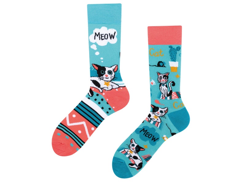 May include: A pair of colorful socks with a cat theme. One sock features a white cat with black spots and the words "MEOW" and "Cat". The other sock features a black cat with white spots and the words "MEOW" and "Cat".