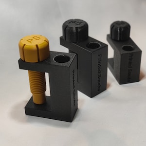 May include: Three black 3D printed clamps with a yellow knob on the top. The clamps are labeled "Printed Smoke".