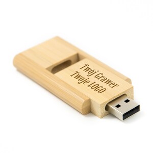 Könnte beinhalten: Ein USB-Stick aus Holz mit einer Schiebekappe. Der Stick ist mit dem Text "Twój Grawer Twoje Logo" graviert.