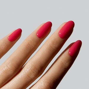 May include: Fingernails with a glossy, vibrant hot pink nail polish. The nails are shaped in a smooth, rounded oval style, showcasing a consistent, opaque, and reflective finish across all visible fingers against a neutral background.