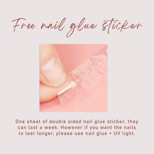 Puede incluir: Primer plano de una mano despegando una pegatina de pegamento para u&ntilde;as de doble cara transparente de una hoja. El texto "Free nail glue sticker" est&aacute; escrito en cursiva. Texto adicional describe la longevidad y el uso con luz UV.