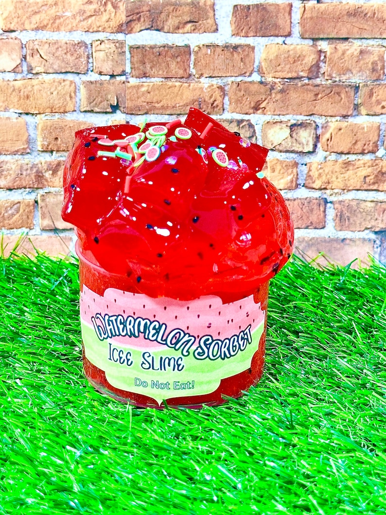 May include: Red watermelon sorbet ice slime in a clear plastic container with a green and white label that reads "Watermelon Sorbet Ice Slime Do Not Eat!"