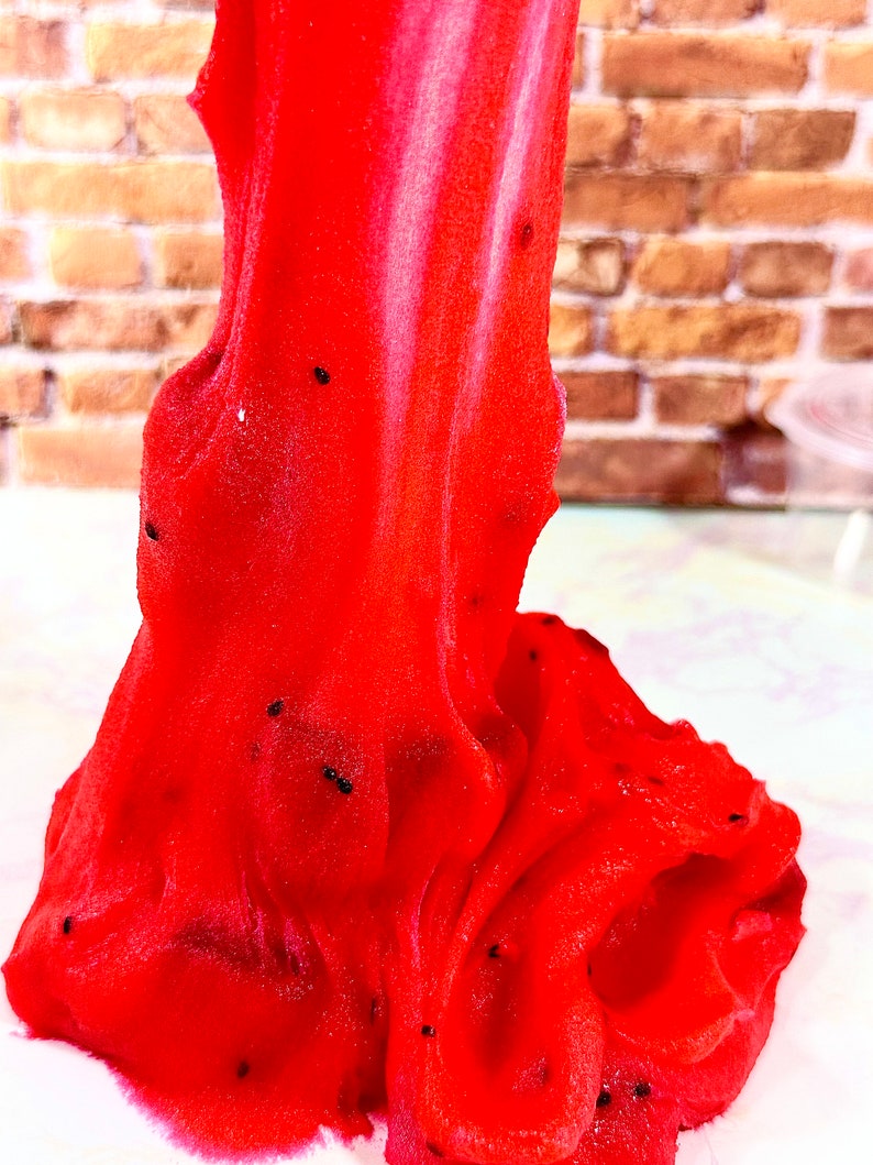 May include: Red slime with black specks, resembling a textured, gooey substance.