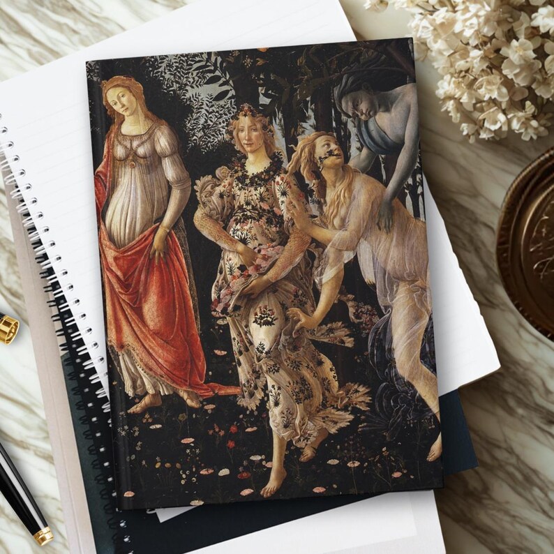 May include: A rectangular notebook featuring a reproduction of Sandro Botticelli's Primavera painting on the cover. The artwork depicts three central female figures in flowing gowns amidst a dark forest background with scattered flowers on the ground.