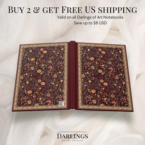 May include: An open notebook with a burgundy cover and floral pattern. The pages are visible, and the cover has a gold border. The text "DARLINGS OF ART DESIGNS" is at the bottom. The image also includes the text "BUY 2 & GET FREE US SHIPPING".