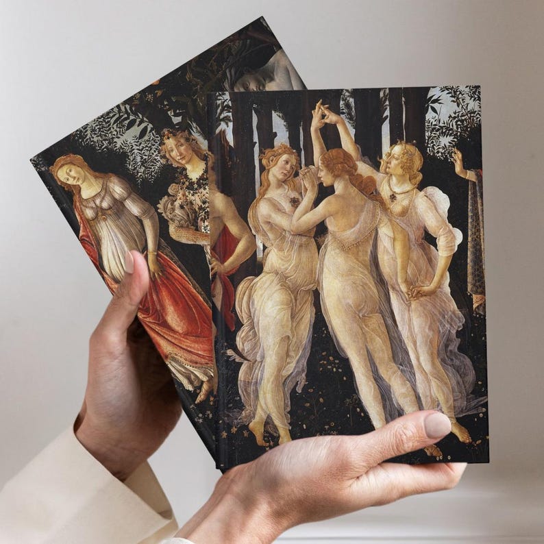 May include: Two rectangular notebooks featuring a reproduction of Botticelli's Primavera painting on the covers. The artwork displays three figures dancing in sheer white garments against a dark forest background, with another figure in a red dress.