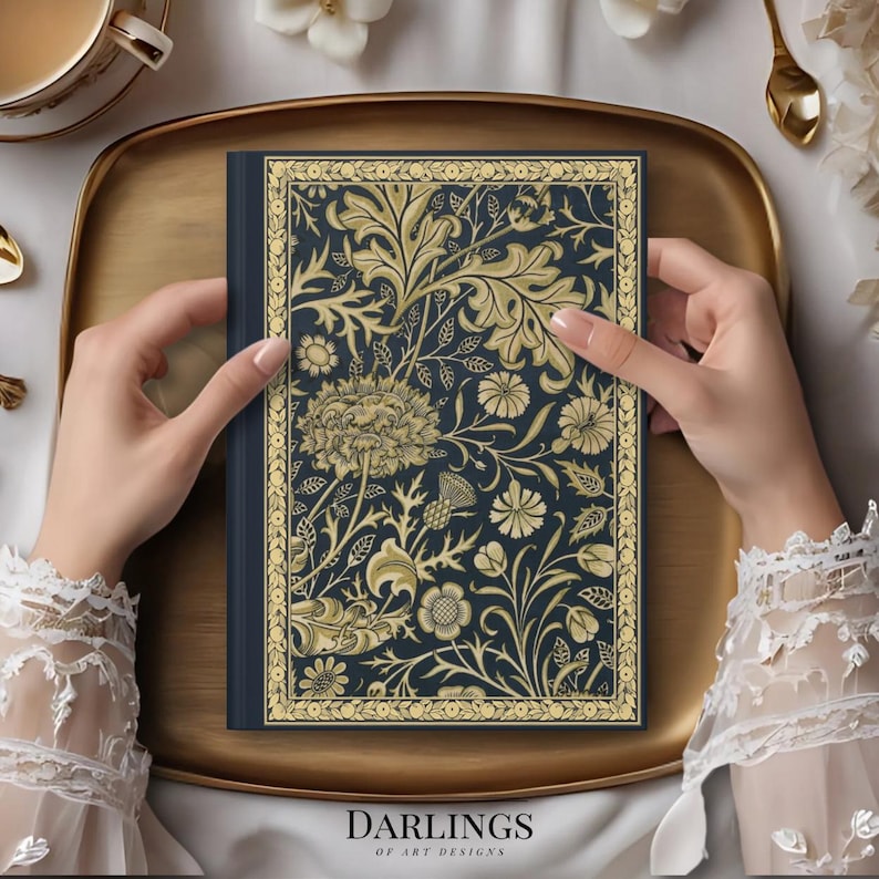 May include: A dark blue notebook with a gold floral design and the text "Darlings of Art Designs" on the cover.