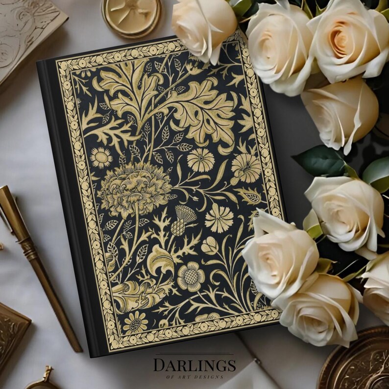 May include: A black journal with a gold floral design on the cover. The cover features a repeating pattern of leaves, flowers, and stems. The text "DARLINGS OF ART DESIGNS" is printed in gold at the bottom of the cover.