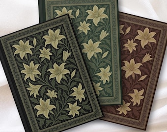 May include: Three hardback journals with floral lily designs. The journals are in shades of black, green, and brown. Each journal features a detailed lily pattern with cream-colored flowers and green leaves.