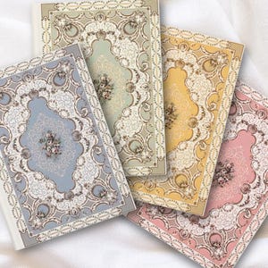 May include: Four rectangular notebooks featuring intricate, ornate white filigree borders and central floral bouquets. The covers are colored in soft shades of sage green, dusty blue, golden yellow, and pale pink, each with a distinct rectangular frame.