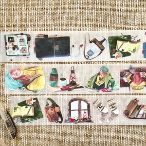 May include: Washi tape with watercolour illustrations of travel and cosy scenes. The tape features images of a journal, a satchel, a thermos, a window, and a pair of socks. The tape is on a woven background.