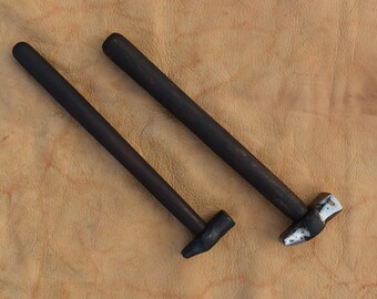 May include: Two black handled hammers with metal heads. The hammers have different sized heads.
