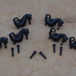 May include: Six black metal seahorse cabinet knobs with six black screws.