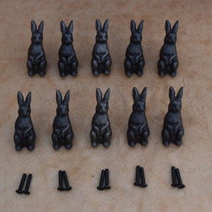 以下が含まれることがあります： 黒色のアンティーク調仕上げの鋳鉄製のウサギの引き出しノブ12個と、黒いネジ12個