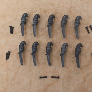 May include: Ten black metal parrot-shaped drawer pulls with screws.