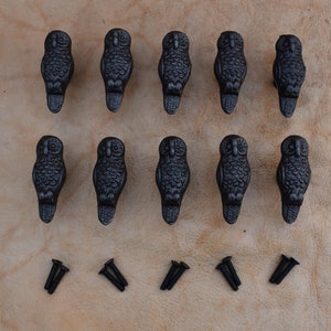 以下が含まれることがあります： 詳細なデザインが施された、黒い鋳鉄製のフクロウの引き出しノブが12個。ノブは2列に6個ずつ配置されています。各ノブには、取り付け用のネジが2本付属しています。