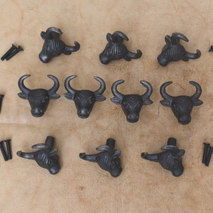 Puede incluir: Diez pomos de armario de cabeza de toro de metal negro con tornillos. Los pomos tienen un acabado rústico y son perfectos para agregar un toque de estilo farmhouse a la decoración de tu hogar.