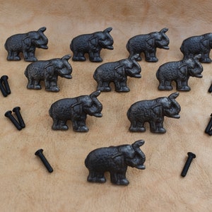 May include: Ten black cast iron elephant drawer pulls with a textured finish and ten black screws.
