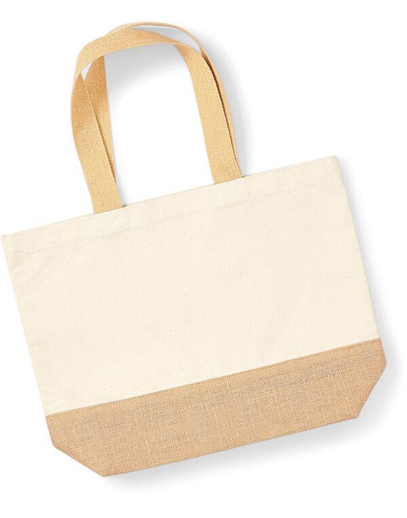 May include: A natural canvas tote bag with a jute bottom. The bag has two long, natural canvas straps.