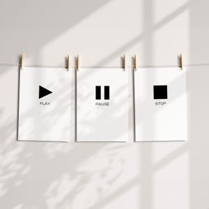 May include: Three white prints with black symbols and text. The first print has a play button and the word "PLAY". The second print has a pause button and the word "PAUSE". The third print has a stop button and the word "STOP".