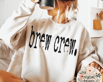 Diseño PNG de Brew Crew, descarga digital de máquina de escribir retro para amantes del café.