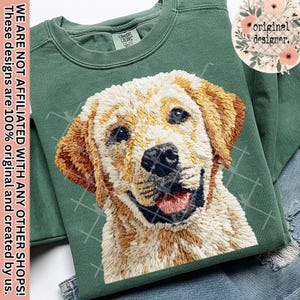 Könnte beinhalten: Grünes Sweatshirt mit einem gestickten Golden Retriever Hund. Der Hund lächelt und zeigt seine Zunge. Das Sweatshirt hat ein Etikett mit der Aufschrift "COMFORT COLORS". Das Design ist original. Der Text "original designer" ist ebenfalls sichtbar.