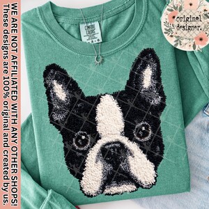 May include: A seafoam green long-sleeved shirt with a black and white Boston Terrier dog design. The dog's face is textured, with a grid pattern overlay. A silver necklace hangs near the collar. The shirt has a Comfort Colors tag.