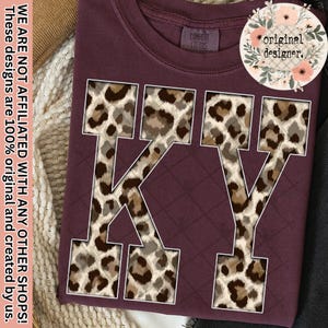 May include: Burgundy-colored sweatshirt with the letters "KY" in a white outline, filled with a leopard print pattern. The text "original designer" is in a floral design. The text "WE ARE NOT AFFILIATED WITH ANY OTHER SHOPS! These designs are 100% original and created by us." is also visible.