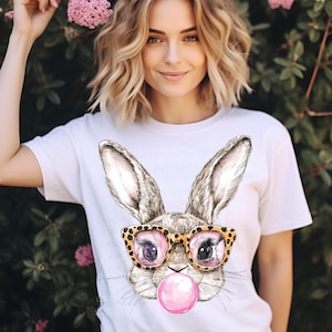 May include: White t-shirt with a graphic of a bunny wearing leopard print sunglasses and blowing a pink bubble.