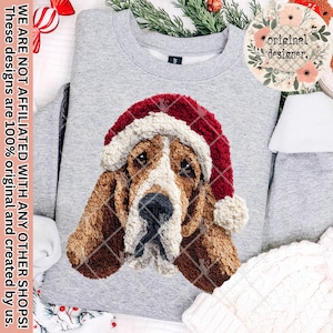 Könnte beinhalten: Graues Sweatshirt mit einer Stickerei eines Basset Hounds mit roter und weißer Weihnachtsmütze. Das Hundedesign steht im Mittelpunkt. Der Text auf der linken Seite lautet: "WE ARE NOT AFFILIATED WITH ANY OTHER SHOPS! These designs are 100% original and created by us."