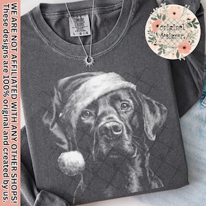 Puede incluir: Camiseta de manga larga gris oscuro con un gráfico en blanco y negro de un perro con un gorro de Papá Noel. La camiseta tiene el texto "original designer." y "WE ARE NOT AFFILIATED WITH ANY OTHER SHOPS! These designs are 100% original and created by us."