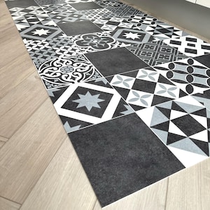 Puede incluir: Alfombra de suelo de patrón blanco y negro con diseños geométricos y florales. La alfombra está hecha de un material duradero y es perfecta para áreas de mucho tráfico.