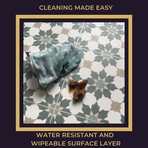 May include: A close-up of a green and white patterned floor tile with a brown stain and a green cloth on the floor. The text "CLEANING MADE EASY" is at the top of the image and the text "WATER RESISTANT AND WIPEABLE SURFACE LAYER" is at the bottom of the image.