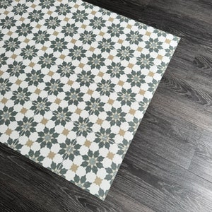 May include: A white, black, and beige patterned floor mat with a geometric design. The mat is made of a durable material and is perfect for high-traffic areas.