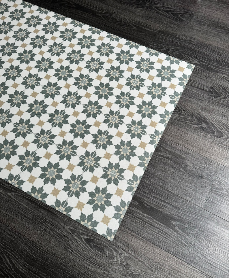 May include: A white, black, and beige patterned floor mat with a geometric design. The mat is made of a durable material and is perfect for high-traffic areas.