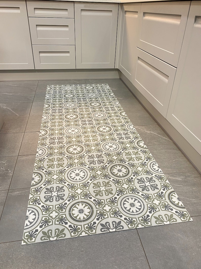May include: A patterned kitchen rug with a geometric design in shades of green, white, and grey. The rug is made of a durable material and is perfect for protecting your floors from spills and dirt.